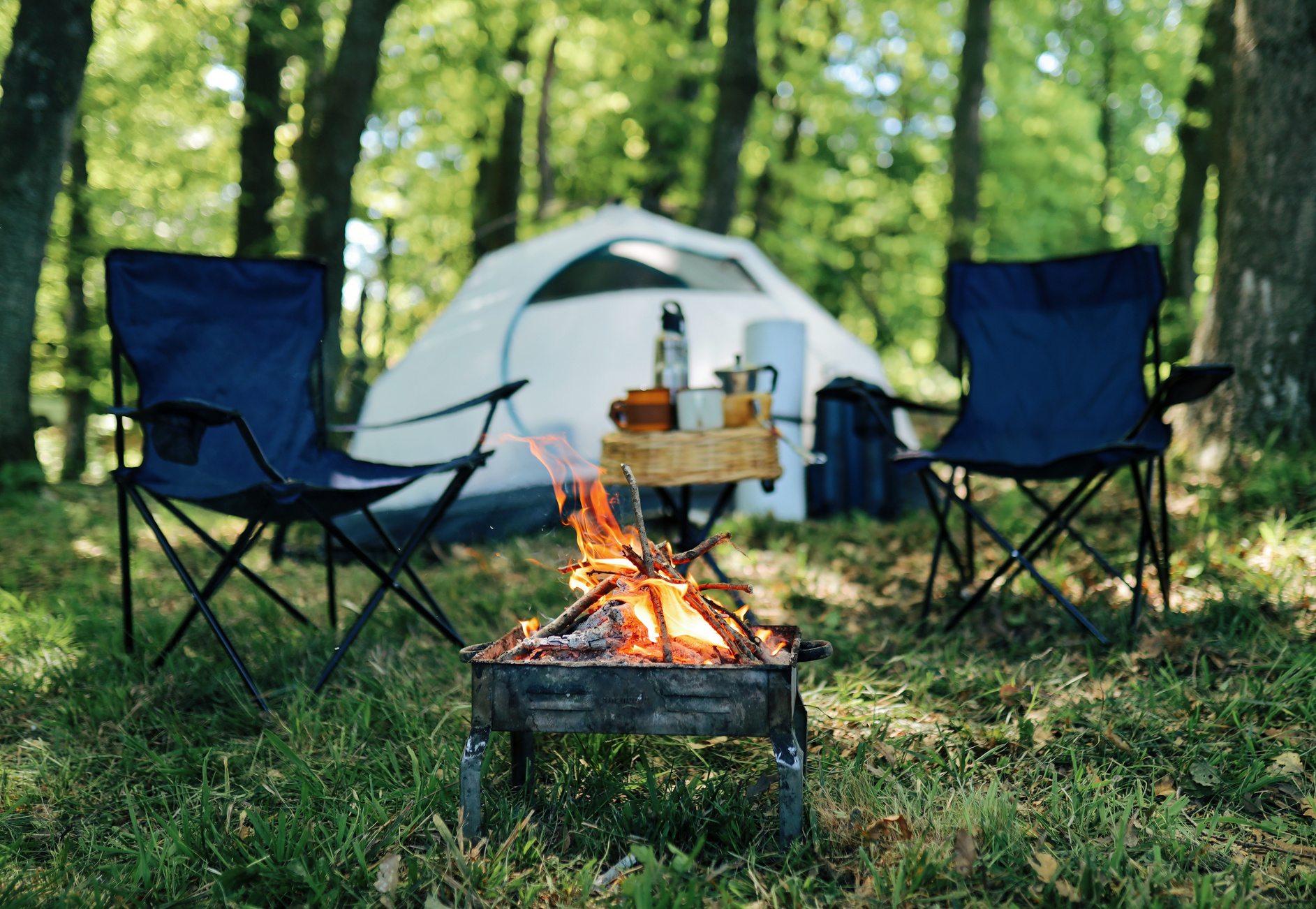 Tent, Chairs, and Burning Campfire Outdoors